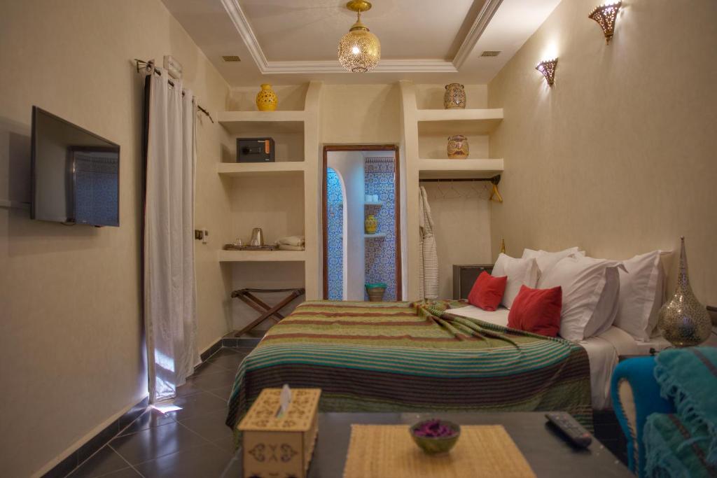 une chambre avec un lit et un canapé dans une pièce dans l'établissement Riad Tama & spa, à Ouarzazate