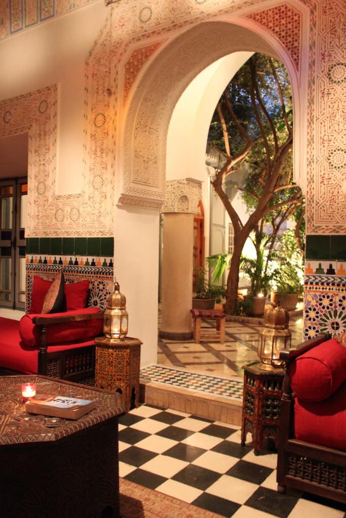 - un salon avec un mobilier rouge et un sol en damier dans l'établissement Riad Sahara Nour, à Marrakech