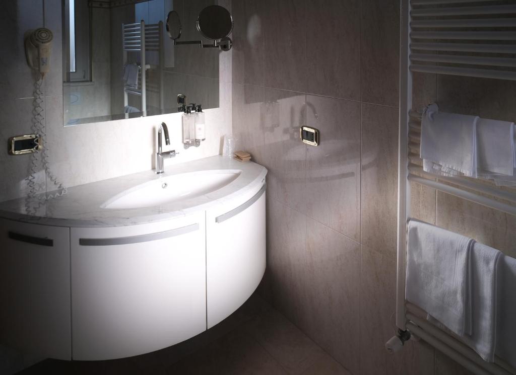 une salle de bain avec un lavabo blanc et un miroir dans l'établissement HOTEL CONCORDE, à SantʼEgidio alla Vibrata