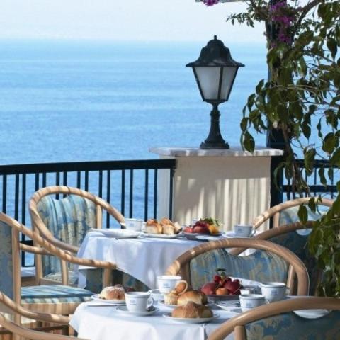 - une table avec des assiettes de nourriture sur un balcon donnant sur l'océan dans l'établissement Hotel Piccolo Paradiso, à Massa Lubrense