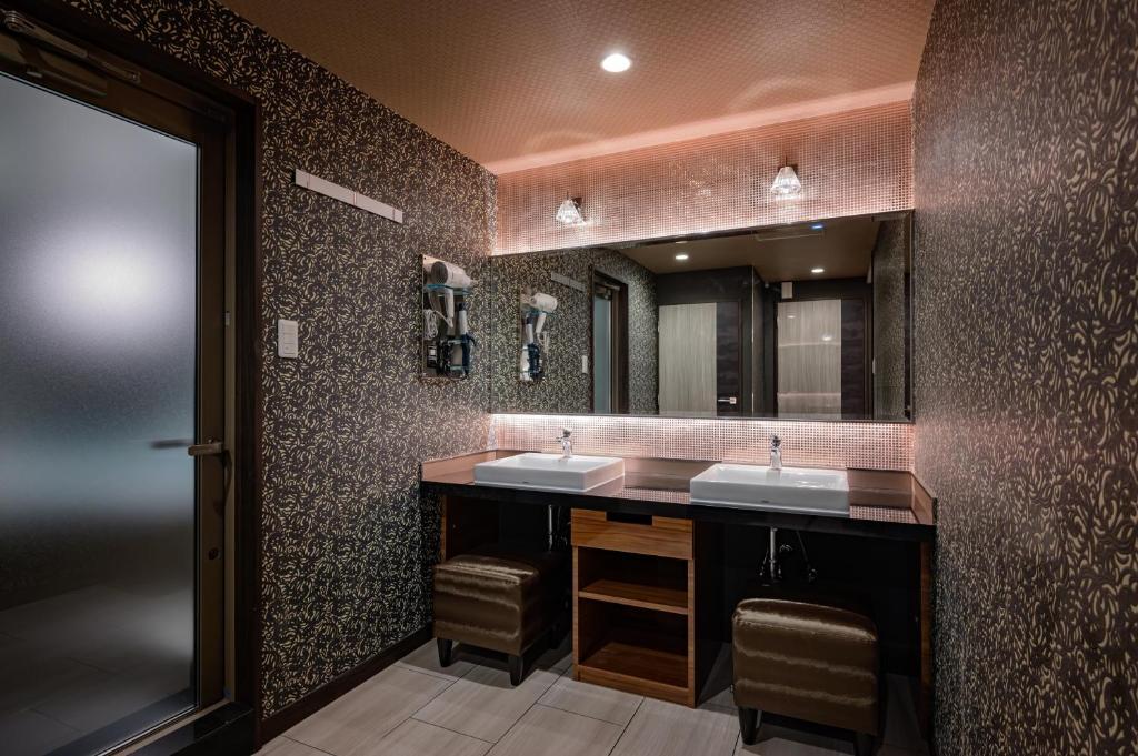 une salle de bain avec deux lavabos et un miroir dans l'établissement HOTEL STAR RESORT aroma, à Maebashi