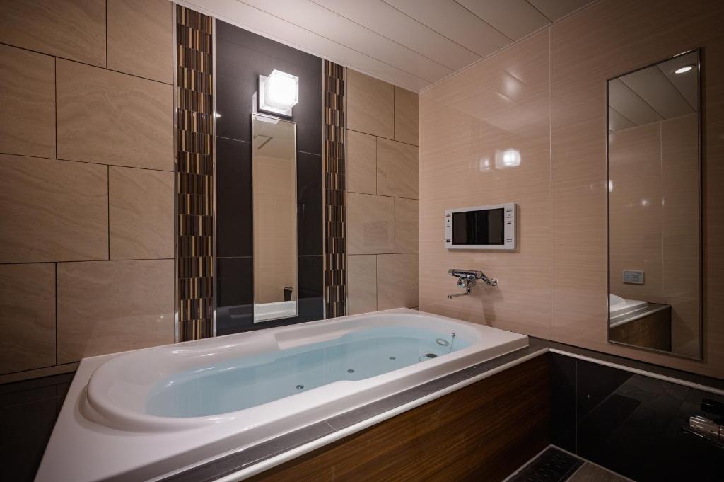 Cette chambre comprend une salle de bains pourvue d'une grande baignoire. dans l'établissement HOTEL STAR RESORT aroma, à Maebashi