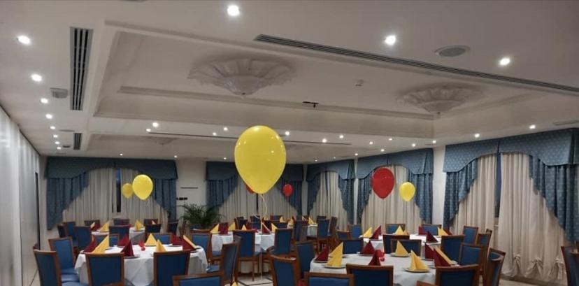 une salle de banquet avec des tables et des ballons jaunes au plafond dans l'établissement HOTEL CONCORDE, à SantʼEgidio alla Vibrata
