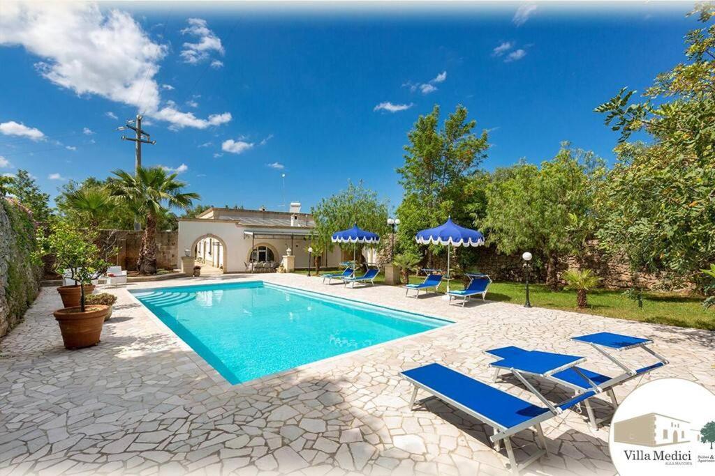 une piscine avec des chaises bleues et une maison dans l'établissement /Historical City/ Villa Medici - Luxury, à Oria