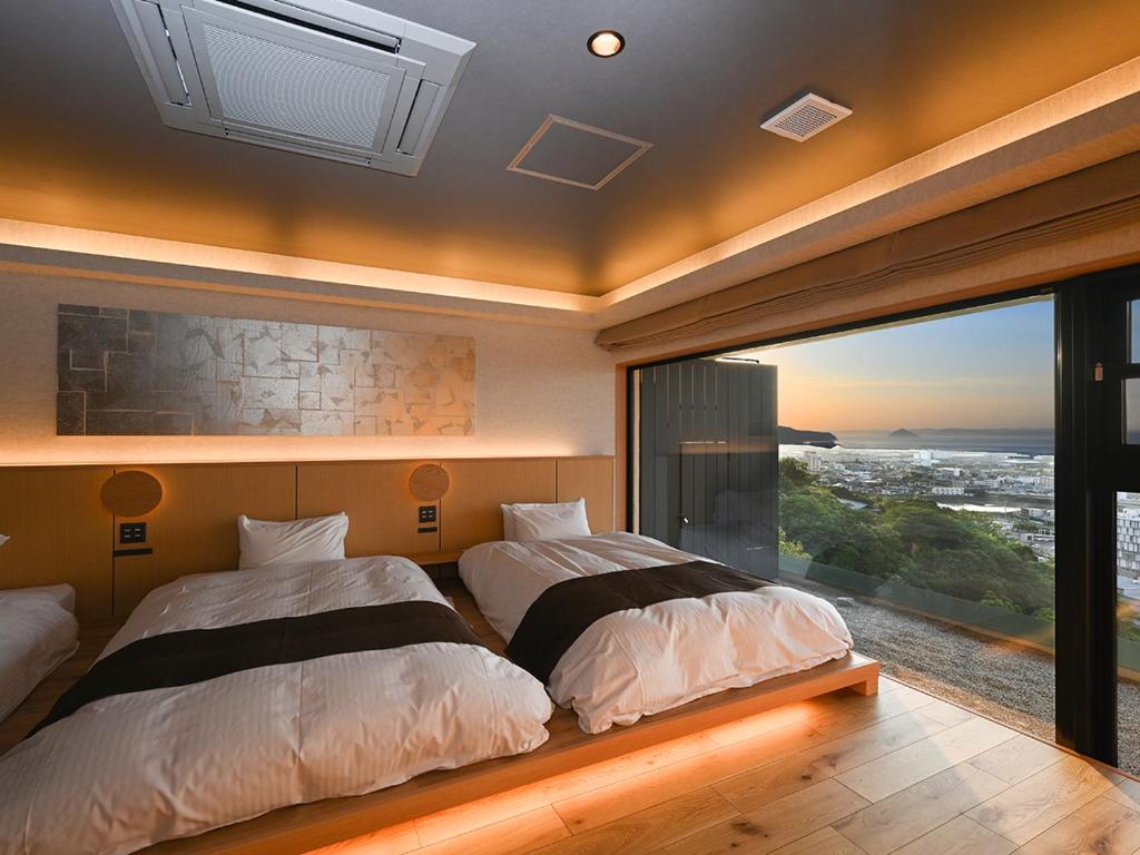 - 2 lits dans une chambre avec une grande fenêtre dans l'établissement Yunaginoyu Hotel Hanajyukai, à Takamatsu 37 autres photos