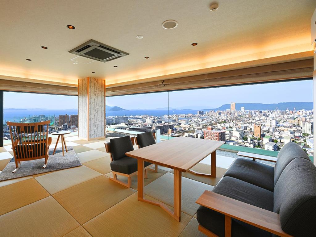 un salon avec une table et une grande fenêtre dans l'établissement Yunaginoyu Hotel Hanajyukai, à Takamatsu