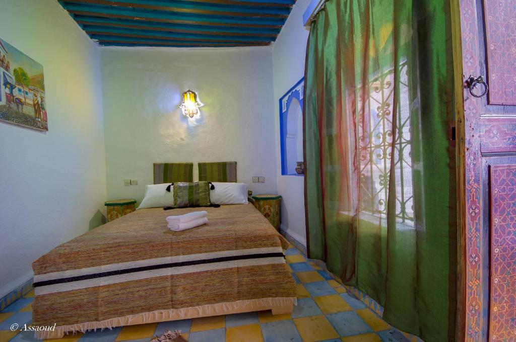 une chambre avec un lit dans une pièce dans l'établissement Dar El Fanne, à Chefchaouen