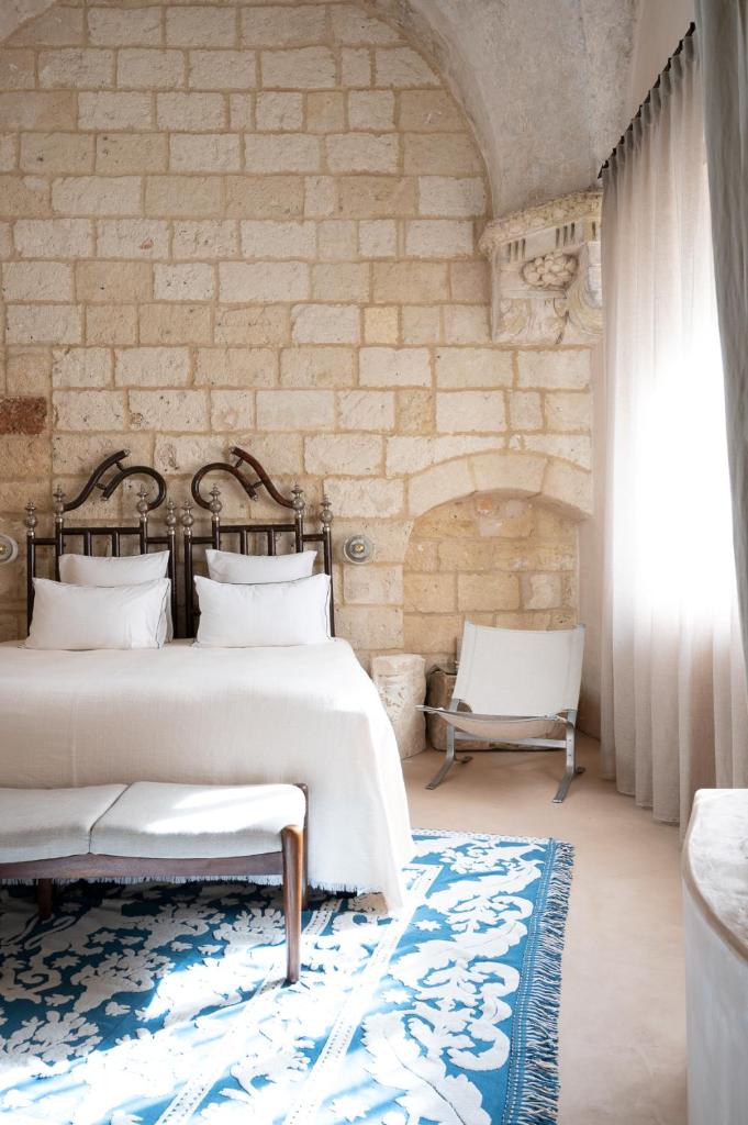 une chambre avec un lit et un mur en pierre dans l'établissement Casa a Corte, Nardò, à Nardò