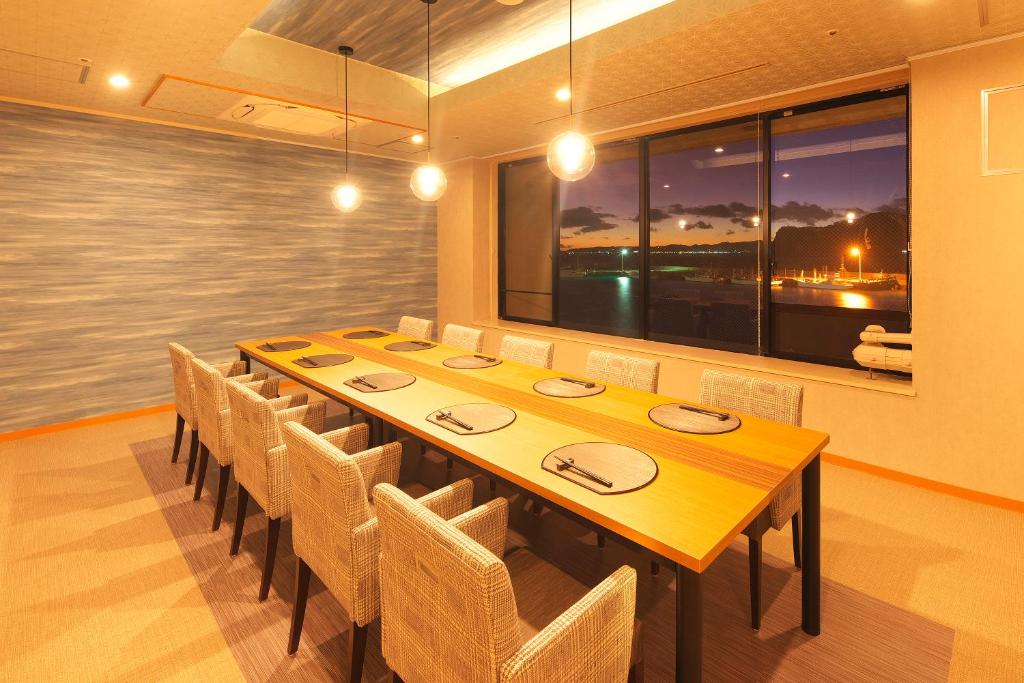 une salle à manger avec une longue table et des chaises dans l'établissement Kichimu, à Kamogawa 37 autres photos