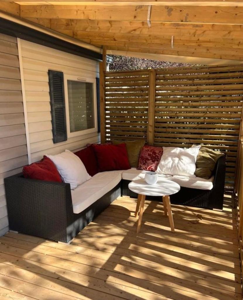 d'une terrasse avec un canapé et une table. dans l'établissement Mobil-Home des Iscles, à La Roque-dʼAnthéron