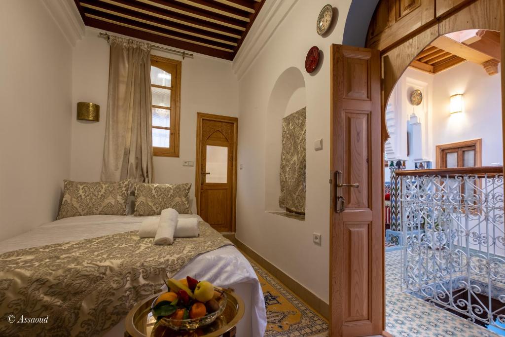 une chambre avec un lit avec un bol de fruits dessus dans l'établissement Riad Bin Souaki, à Chefchaouen