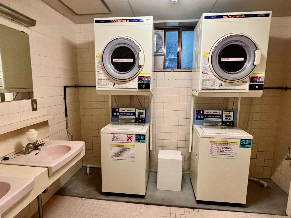une salle de bain avec un lavabo et une machine à laver dans l'établissement Ryokan Kousen Kazeya Group, à Nara