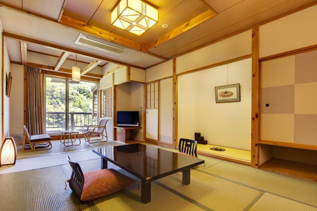 un salon avec une table et des chaises dans l'établissement Ryokan Fushioukaku, à Ikeda
