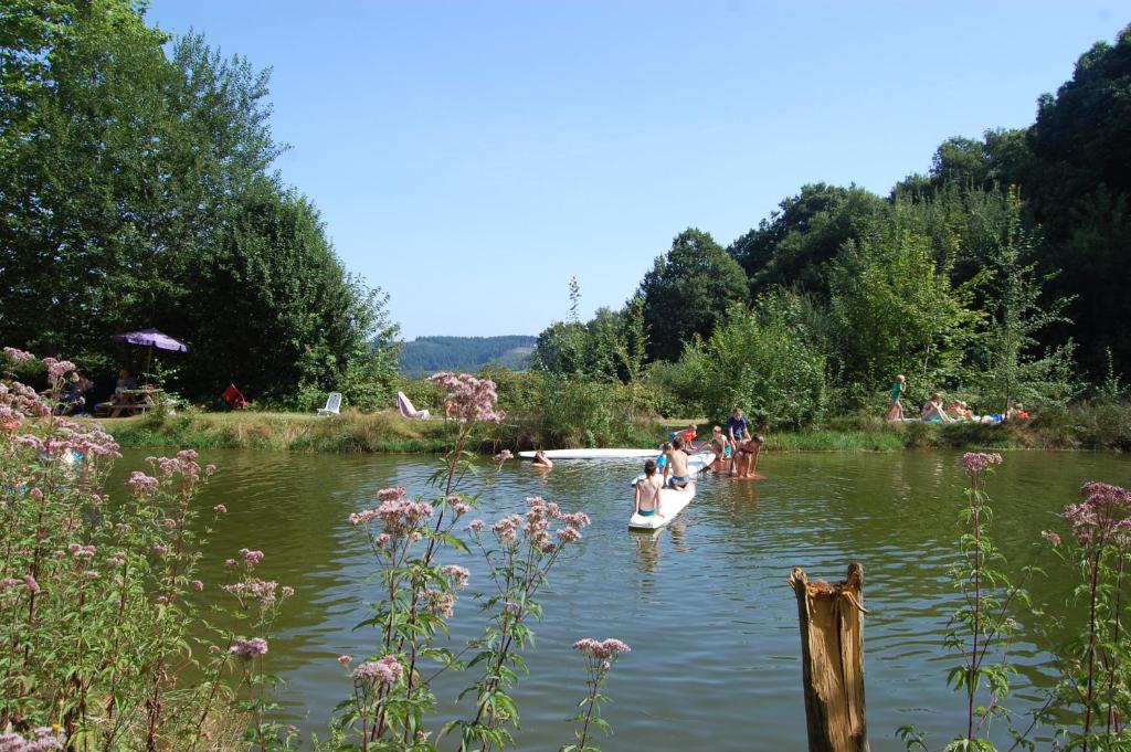 un groupe de personnes sur un bateau dans l'eau dans l'établissement Camping La Forêt du Morvan, à Larochemillay