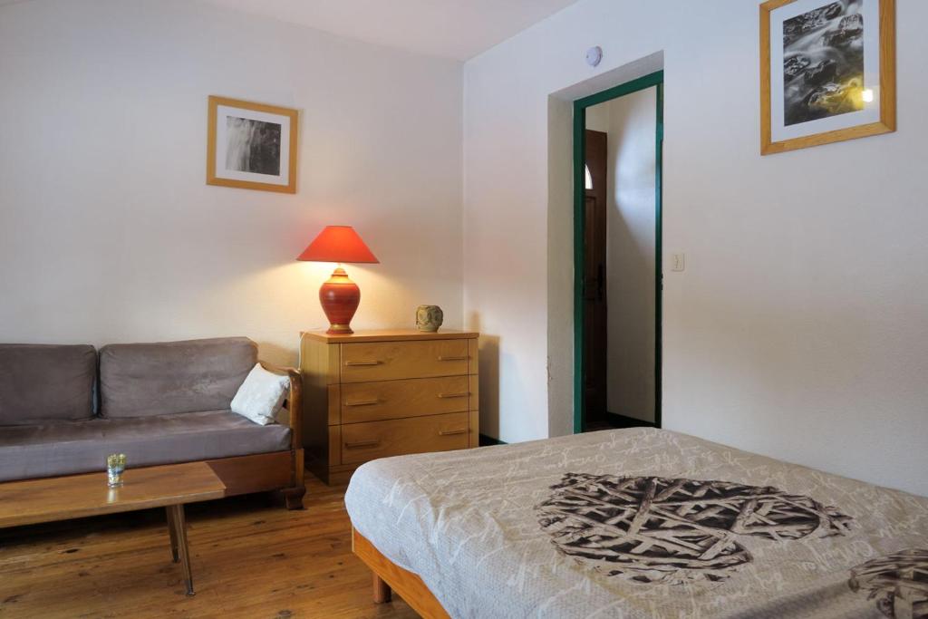 une chambre avec un lit, un canapé et une table dans l'établissement Gîte CROCUS - 2 personnes - "Les Gites du Chalet" à Autrans, à Autrans