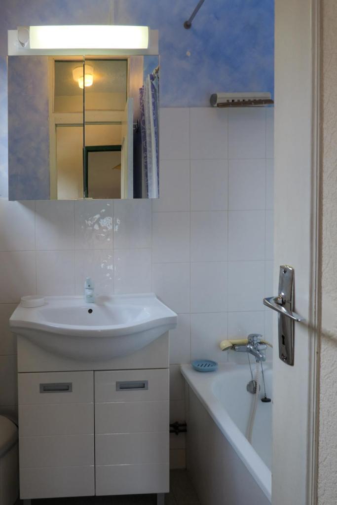 une salle de bain blanche avec un lavabo et une baignoire dans l'établissement Gîte CROCUS - 2 personnes - "Les Gites du Chalet" à Autrans, à Autrans 9 autres photos