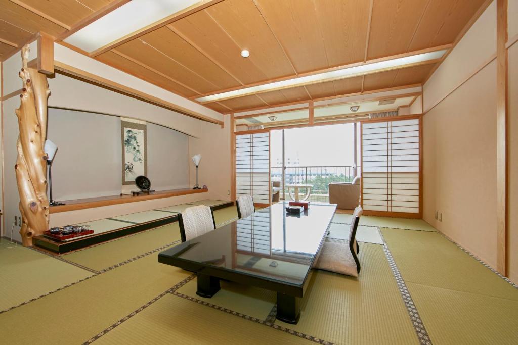 une salle à manger avec une table et des chaises en verre dans l'établissement Shirahama Onsen Kisyu Hanto, à Shirahama