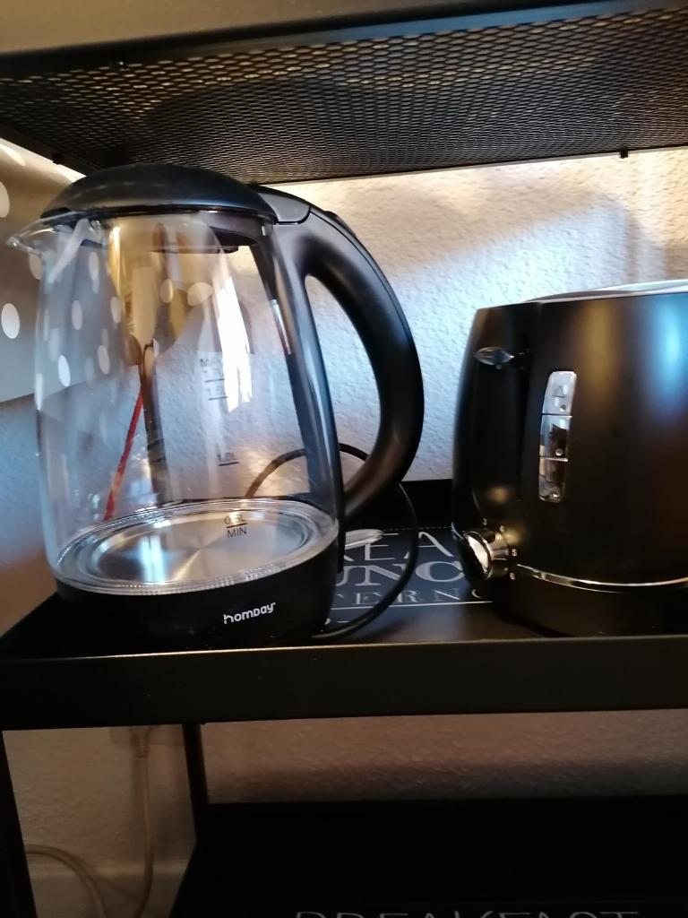une bouilloire assise sur un comptoir à côté d'une tasse dans l'établissement CŒUR D'ALTAÏR RISOUL 1850 Appartement T2 confortable skis aux pieds, à Risoul 32 autres photos