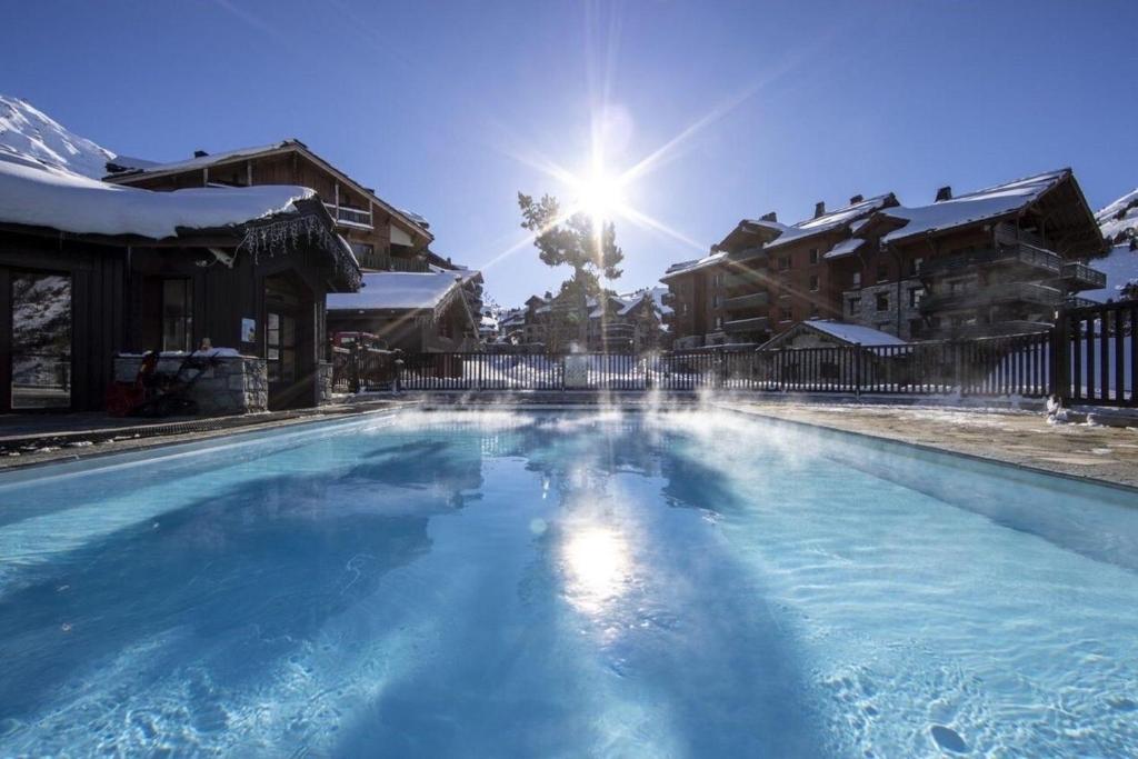 - une piscine au soleil en arrière-plan dans l'établissement Arc 1950 - Chalet des Lys - appt Luxe 4 pers, à Arc 1950