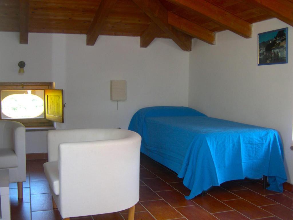 - une chambre avec un lit bleu et une chaise dans l'établissement Il Canale 1861, à San Mauro Cilento