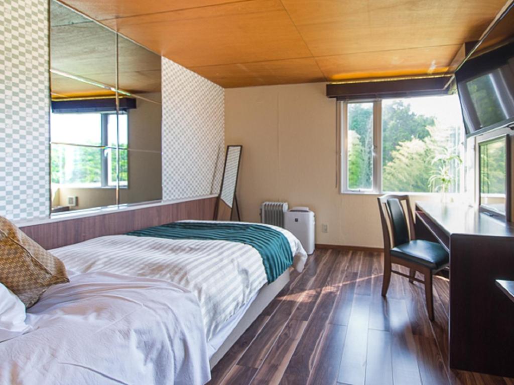 une chambre avec un lit et un bureau et deux fenêtres dans l'établissement LiVEMAX RESORT Ito Kawana, à Itō 126 autres photos