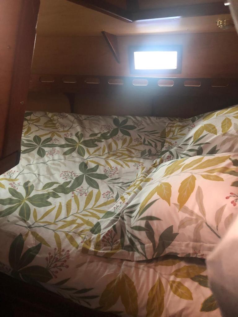 - un lit avec une couette en fleurs et une fenêtre dans l'établissement Cassiopee, à Lorient