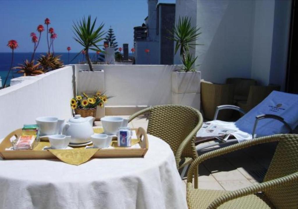 une table avec un plateau avec des tasses et des tasses dessus dans l'établissement Hotel Degli Haethey, à Otrante