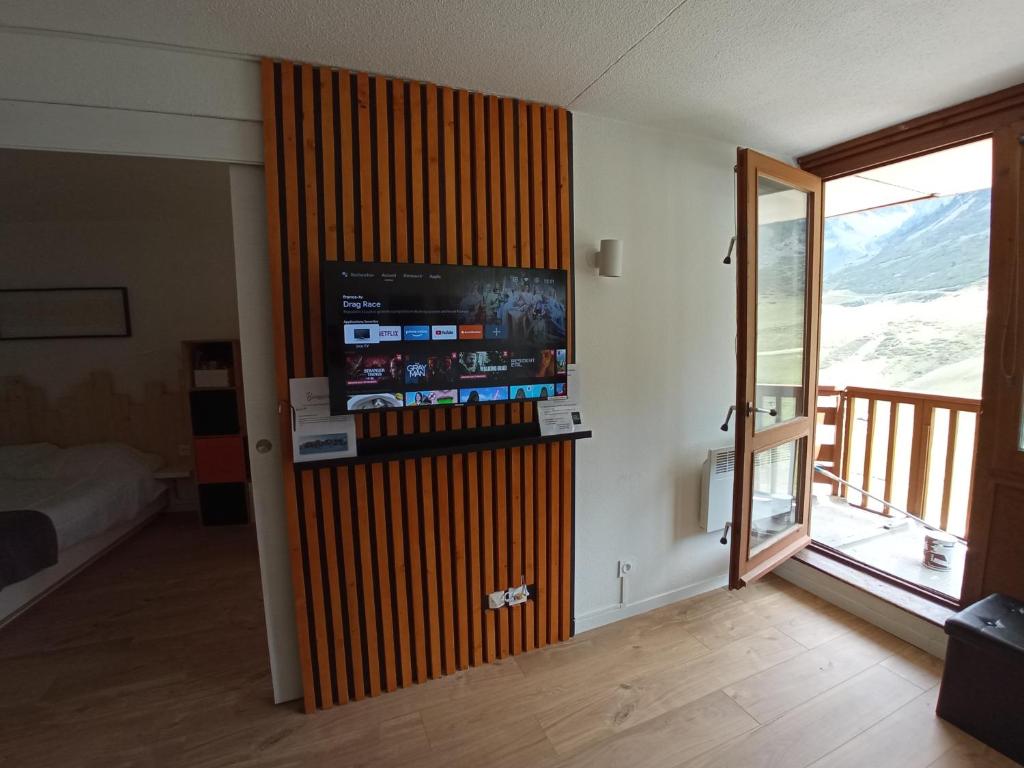 Cette chambre est dotée d'un mur et d'une télévision. dans l'établissement Superbe 3 pieces vue panoramique pied des pistes, à La Mongie