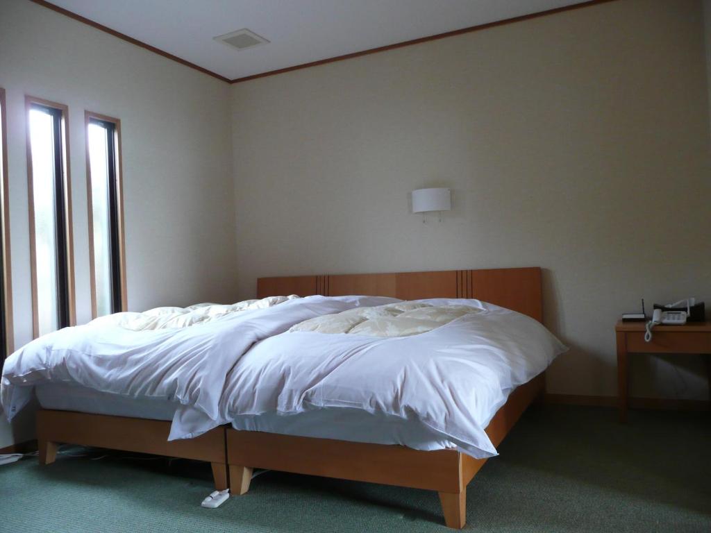une chambre avec un grand lit avec une tête de lit en bois dans l'établissement Donkairo, à Ako