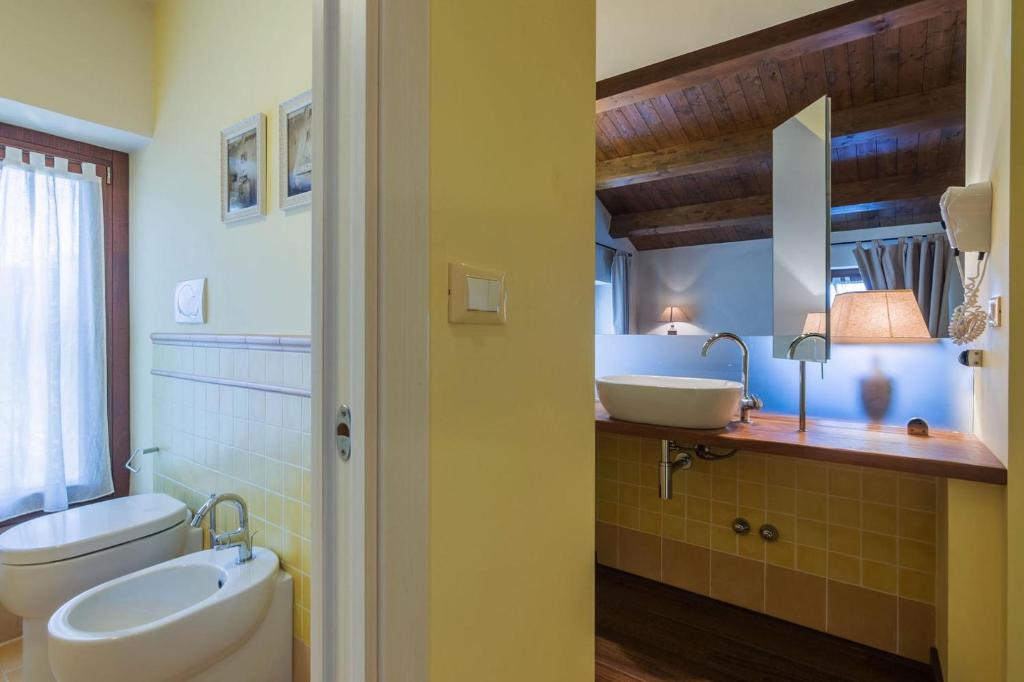 La salle de bains est pourvue de 2 lavabos et de toilettes. dans l'établissement Villa Il Fiore e la Farfalla, à Pesaro