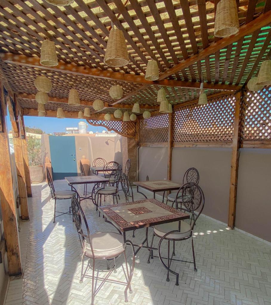 un patio avec tables et chaises sous un plafond en bois dans l'établissement Riad Dar Marrakcha, à Marrakech 37 autres photos