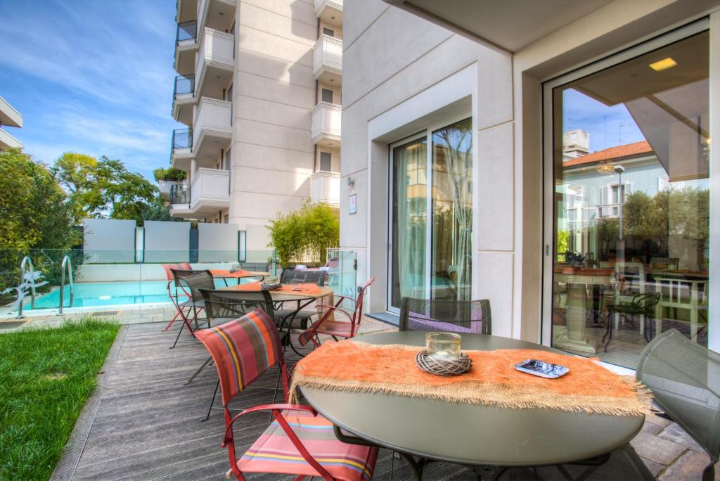 un patio avec tables et chaises sur un balcon dans l'établissement D-Place Hotel & Suite, à Riccione