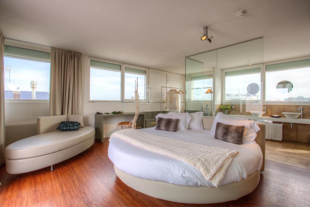 une chambre avec un grand lit blanc et une chaise dans l'établissement D-Place Hotel & Suite, à Riccione 29 autres photos