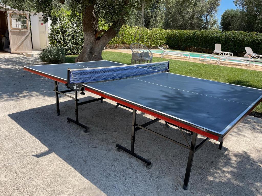 une table de ping-pong devant une piscine dans l'établissement TRULLO CHEFMARCO PRIVATE/SALTWATER SWIMMING POOL, à San Michele Salentino