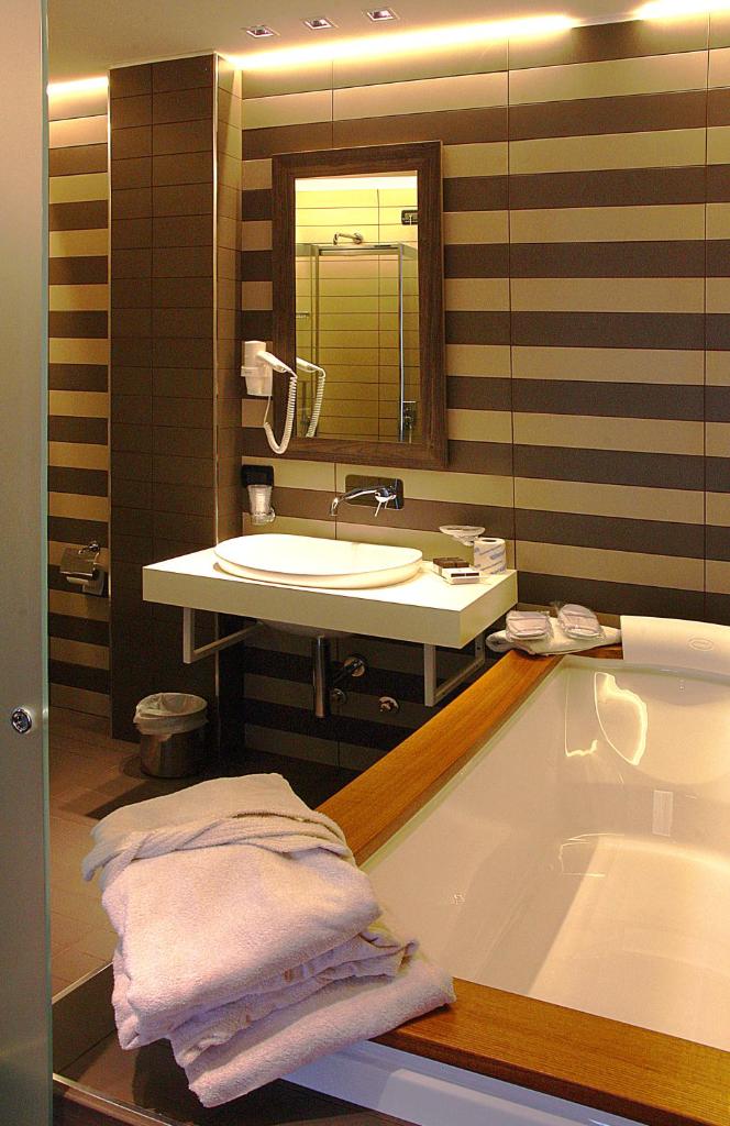 une salle de bain avec une baignoire et un lavabo dans l'établissement Hotel Aurora, à Sirmione