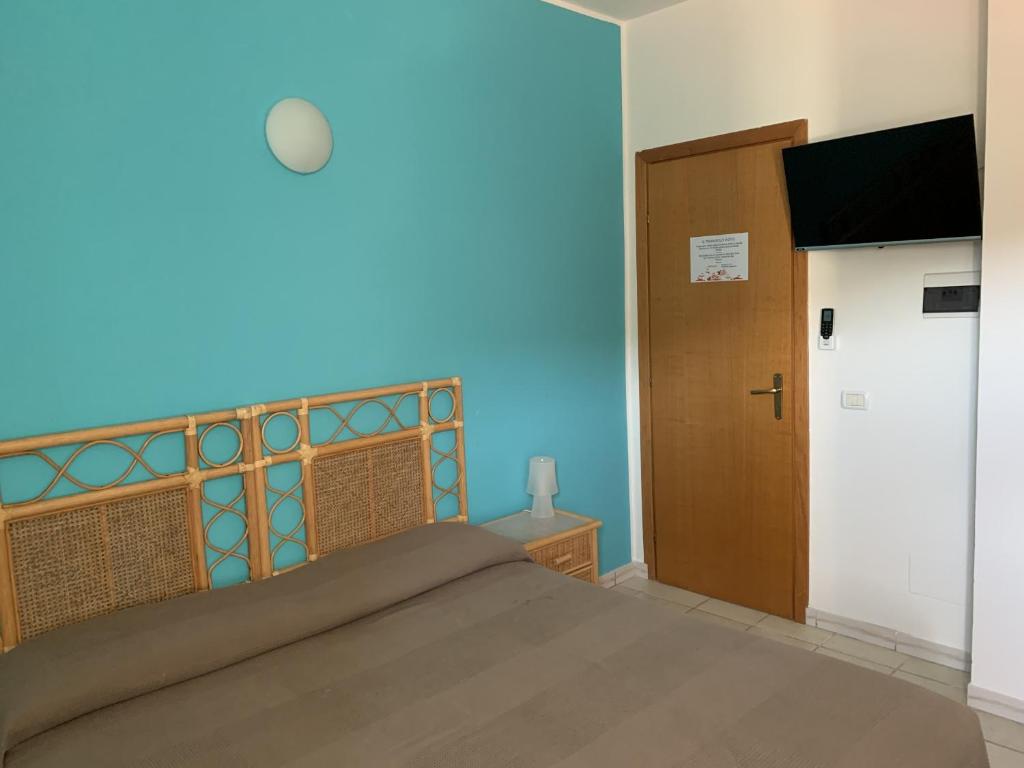 une chambre avec un lit avec un mur bleu dans l'établissement Hotel Il Triangolo, à Agnone Bagni