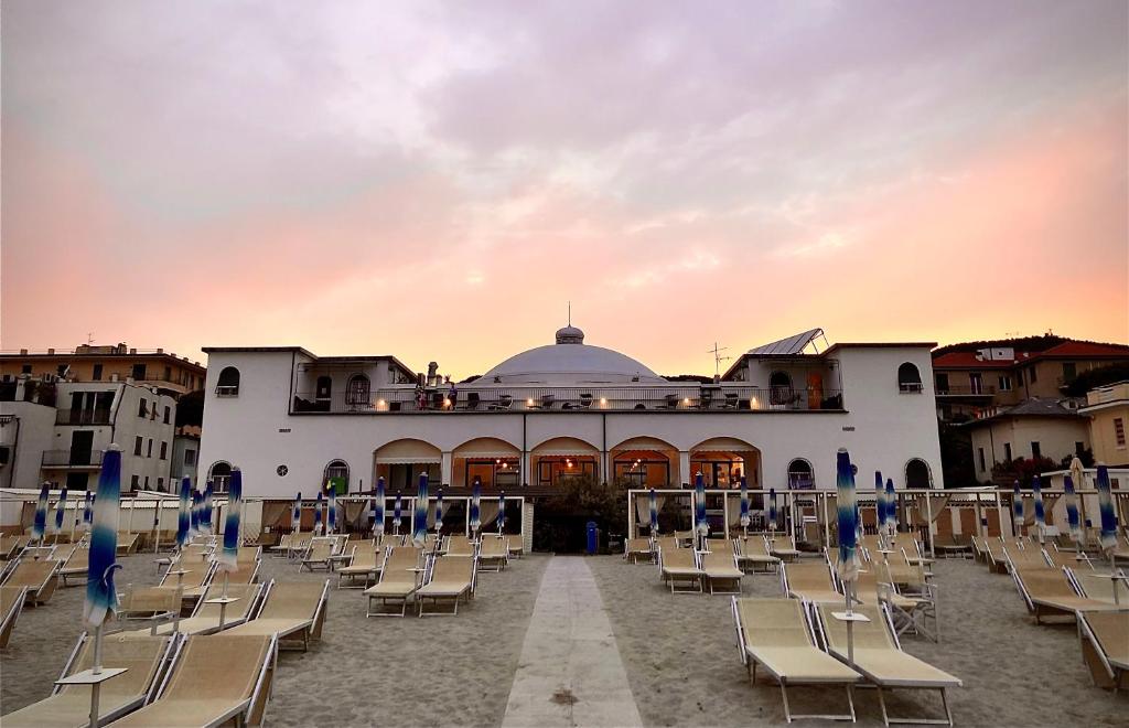 un groupe de chaises devant un bâtiment dans l'établissement Hotel Premuda, à Spotorno
