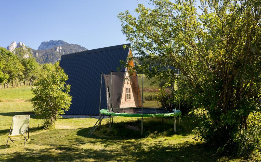 une maison ornithologique assise sur un trampoline dans une cour dans l'établissement Ferme Rony Camp des Découvreurs, à Saint-Nizier-du-Moucherotte