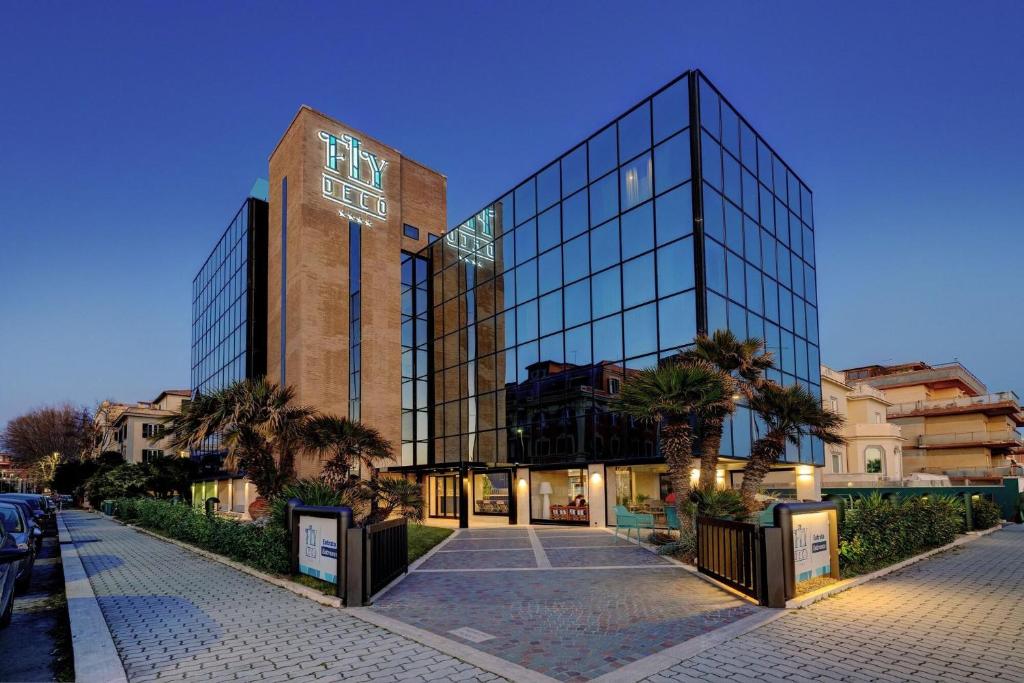 un grand bâtiment en verre avec une horloge. dans l'établissement Fly Decó Hotel, à Lido di Ostia