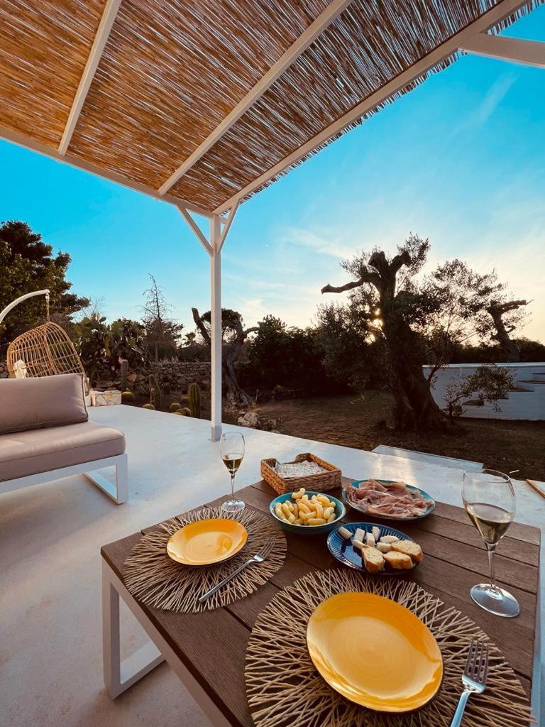une table avec des assiettes de nourriture et des verres à vin dans l'établissement CA' DEL FICO D'INDIA - Antico Casale di charme, à Casarano
