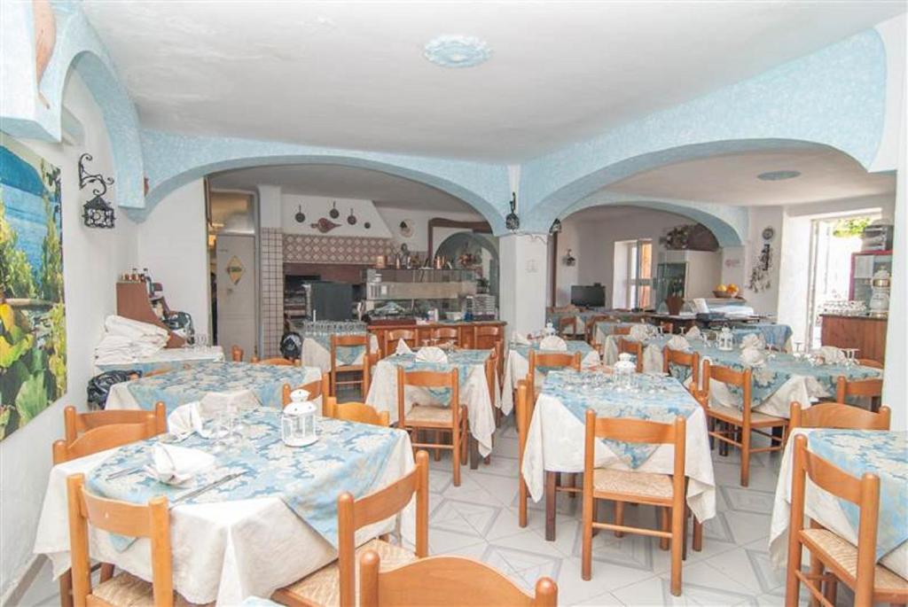 un restaurant avec des tables et des chaises dans une salle dans l'établissement Hotel La Ninfea, à Ischia