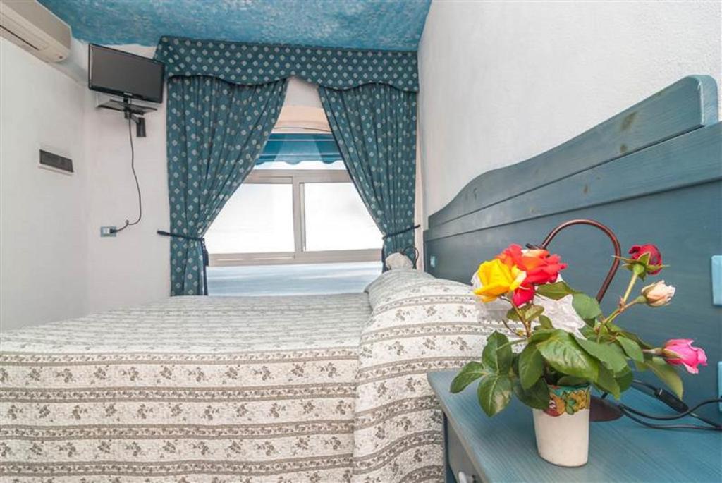 une petite chambre avec un lit et une fenêtre dans l'établissement Hotel La Ninfea, à Ischia
