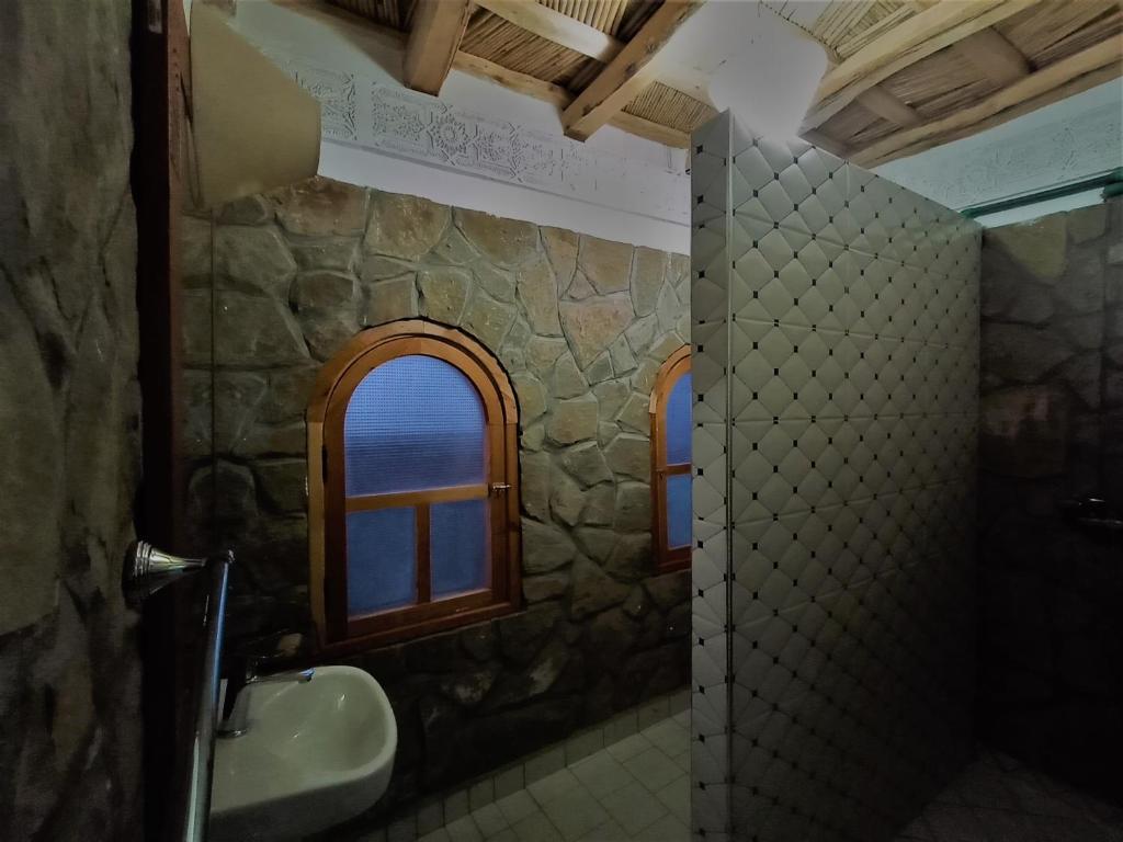 une salle de bain avec un lavabo et une fenêtre dans l'établissement Riad Bleu Afriqua, à Boumalne
