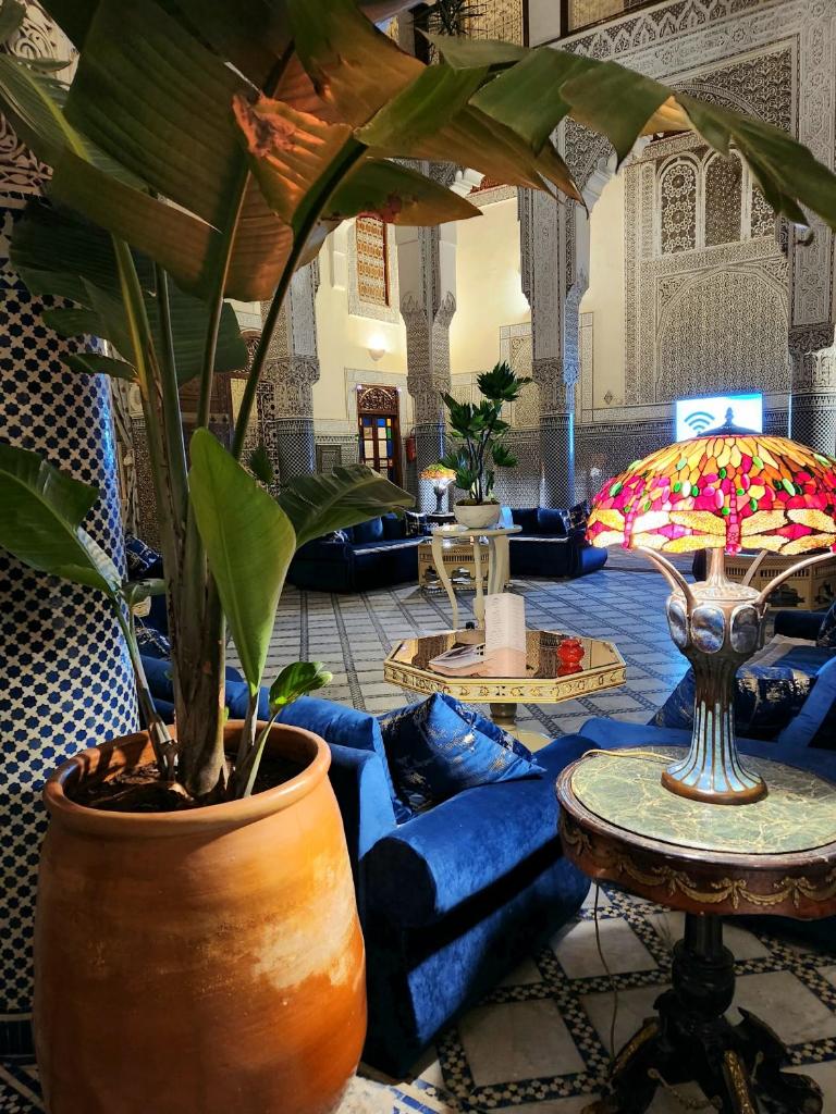 un salon avec un canapé bleu et une plante dans l'établissement Le Riad Palais d'hotes Suites & Spa Fes, à Fès 37 autres photos