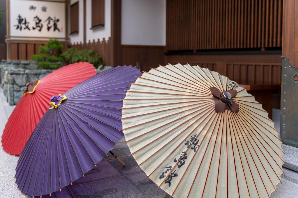 deux parapluies assis l'un à côté de l'autre dans l'établissement Onyado Shikishima-kan, à Kotohira