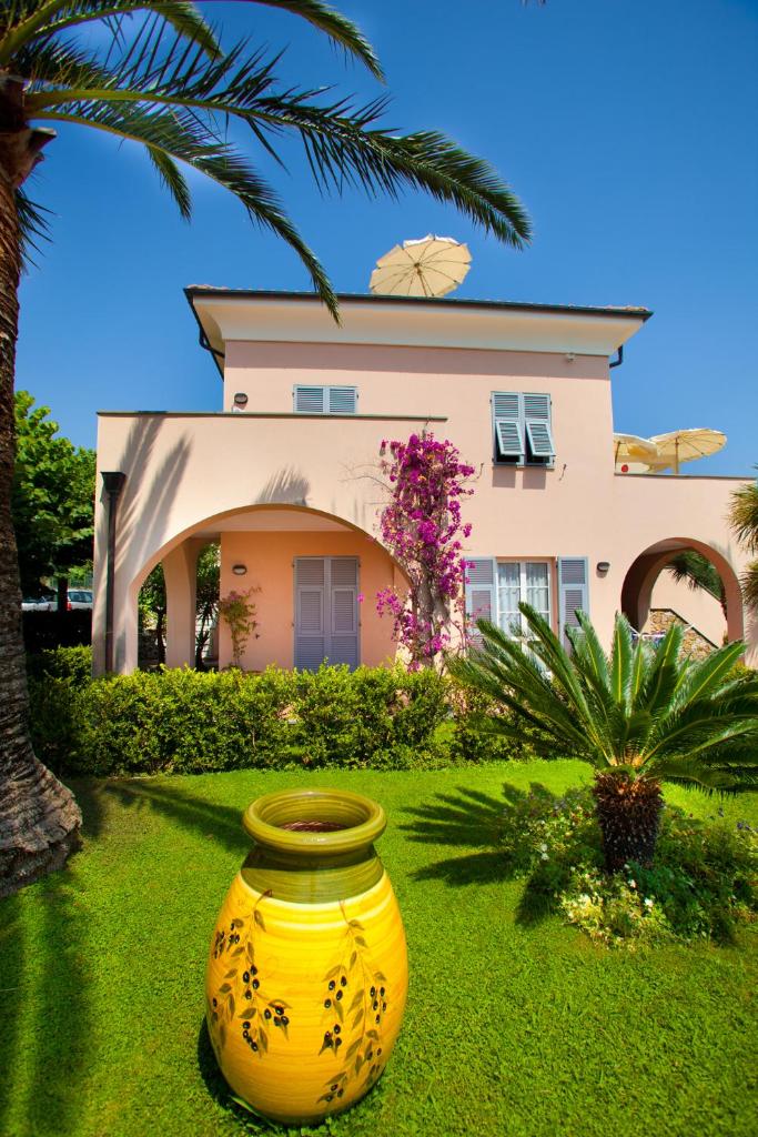 un grand vase jaune assis devant une maison dans l'établissement Residence Pian Dei Boschi, à Pietra Ligure