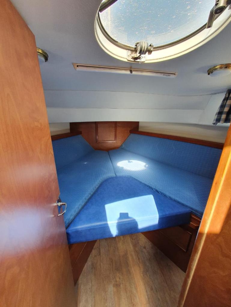 Cette petite chambre est dotée d'un sol bleu dans une porte. dans l'établissement Magnifique bateau au coeur du Nivernais à l'étang de BAYE, à Bazolles