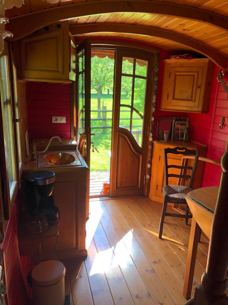 une cuisine avec un évier et une cuisinière dans une pièce dans l'établissement ROULOTTE CAPUCINE, à Ablon