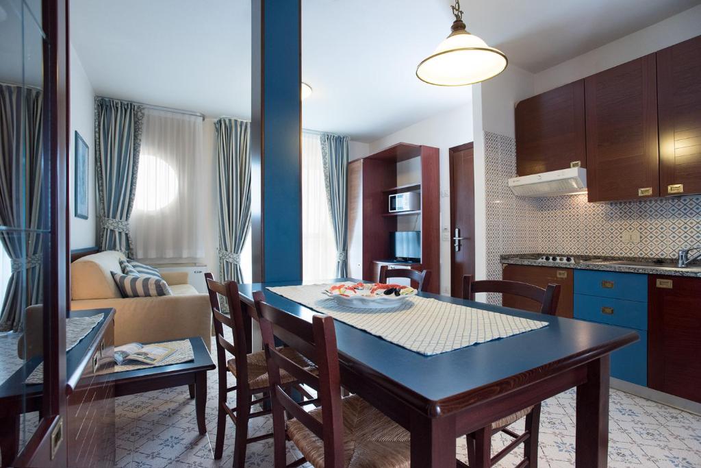 une cuisine et une salle à manger avec une table et des chaises dans l'établissement Aparthotel Holiday, à Bibione