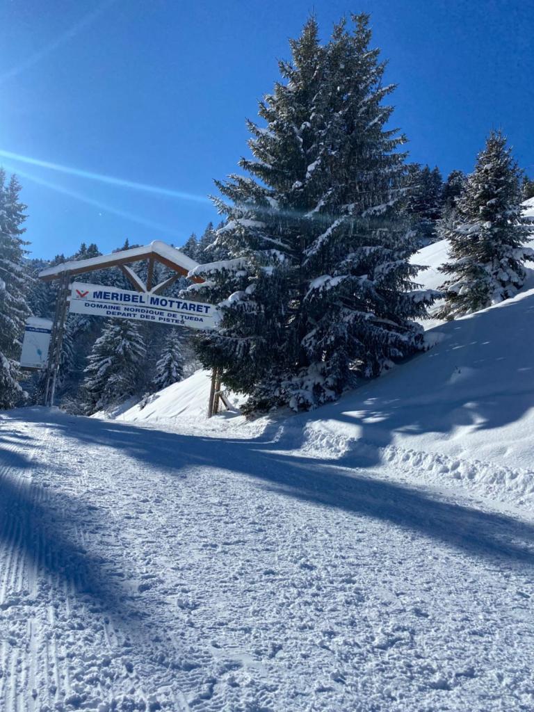 une pente enneigée avec un panneau et des arbres dans l'établissement Chalet Olympie, Appartement avec balcon et vue montagne, ski aux pieds, Méribel-Mottaret, à Méribel 20 autres photos